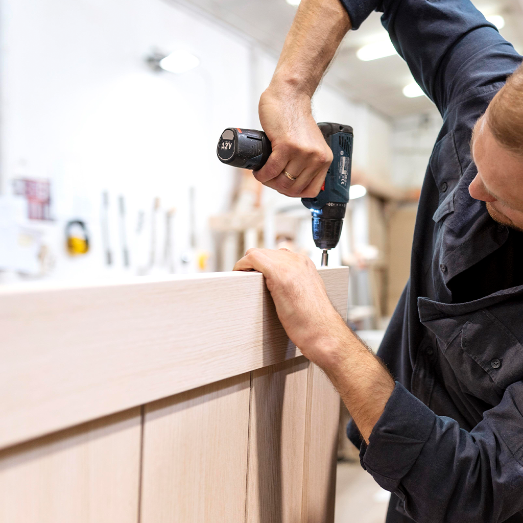 Домашен майстор сглобява мебели, монтира рафтове и окачва телевизор в подреден дом